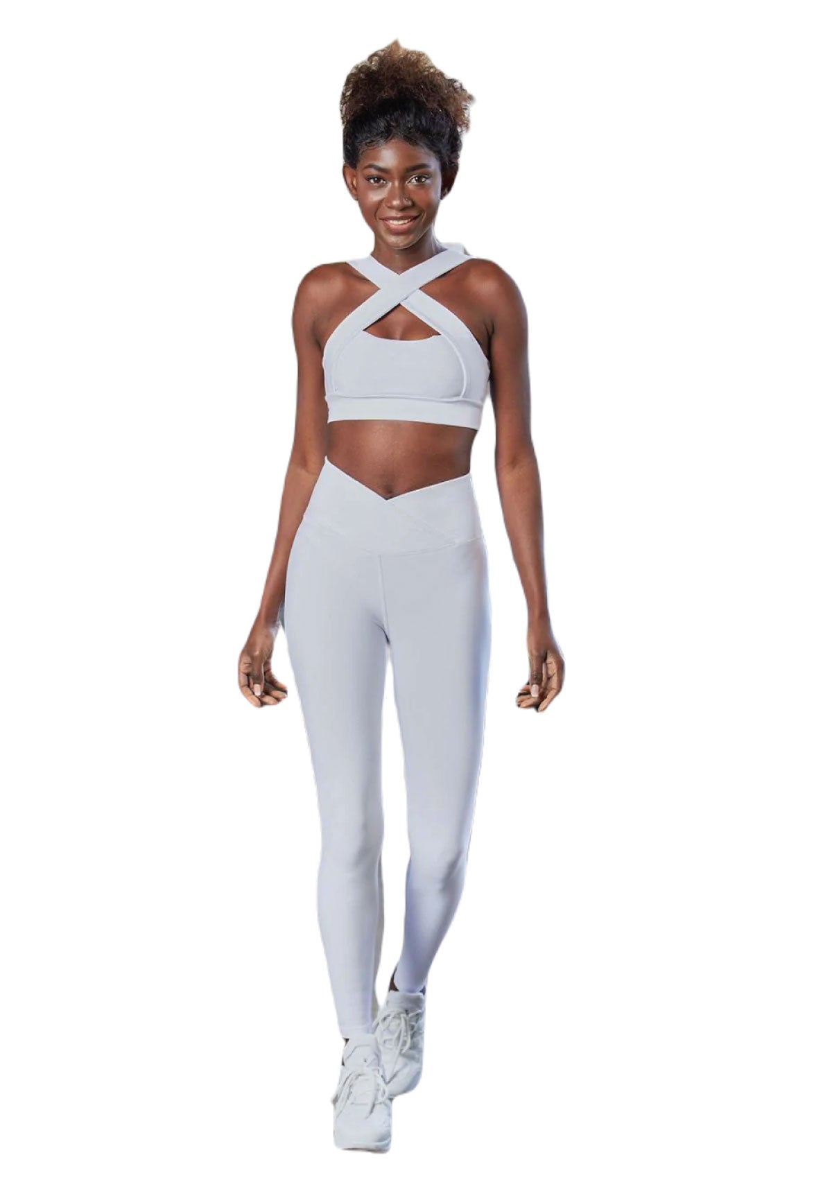 Person in hellblauen Lismina 1085 Ve Waist Leggings lächelt und geht auf einem weißen Yoga-Hintergrund vorwärts.